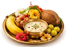 A brass thali of Navratri prasad: a bowl of kheer, bananas, coconut, fruit and marigolds